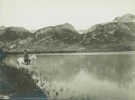 Unidentified man on horseback standing next to Brule Lake looking west