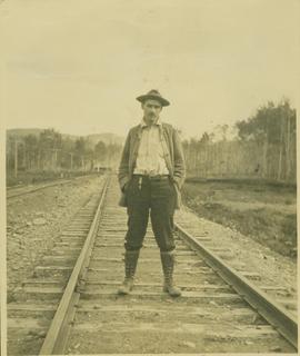 Unidentified man posing for a photo on the train tracks