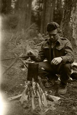 Soldier cooking over campfire