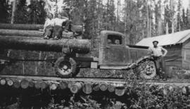 Logging truck on corduroy log road with passengers