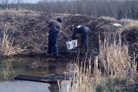 Gathering soil samples at pond