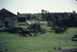 Old buildings and farm equipment in field next to a suburb in the Delta-Richmond area