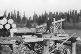 Men on log deck into a sawmill