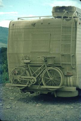 Mud covered bicycle and camper