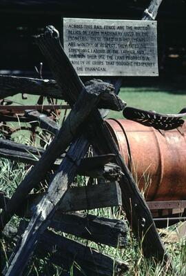 Rusted farm machinery and sign at Father Pandosy Mission