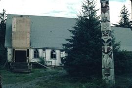 Totem pole in front of decaying church at Masset in the Queen Charlotte Islands