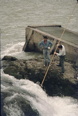 Two men gaffing fish near Moricetown