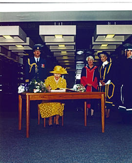 Queen Elizabeth II signs guest book while Chancellor Iona Campagnolo, University Librarian Pat Ap...