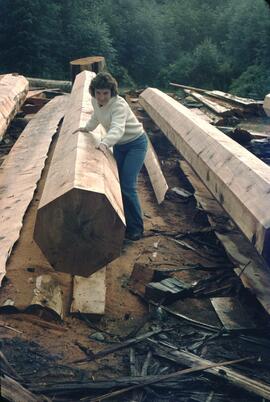 Joan Sawicki with logs prepared for totem pole carving at Skidegate in the Queen Charlotte Islands