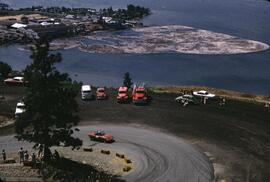Car racing at Knox Mountain with view of S.M. Simpson Ltd. mill and log booms