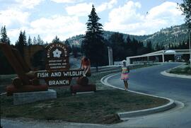 Women posing by BC Fish and Wildlife Branch sign at the Kootenay Fish Hatchery