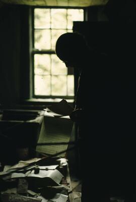 Gordon Gram looking through material in abandoned house in the Nitinat-Clo-oose area on the West Coast Trail