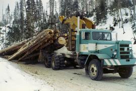 Arch-logging truck pulling a large cluster of logs