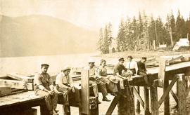 Collison family sitting on dock in Portland Canal, BC