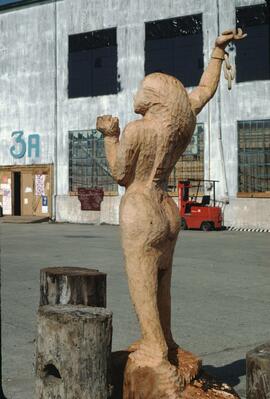 Incomplete wood sculpture of a woman breaking chains at the United Nations Habitat Conference