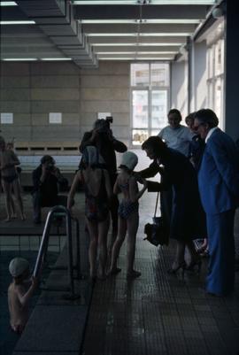 Iona Campagnolo interacting with a young female swimmer at an aquatic centre in East Germany