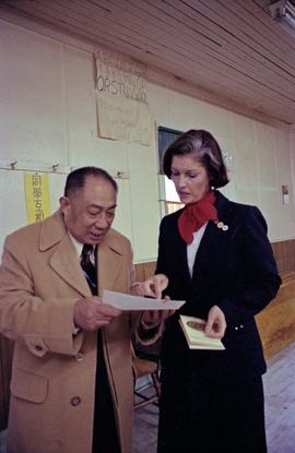Iona Campagnolo examines a document with Earl Mah in the Prince Rupert Chinese Senior Centre