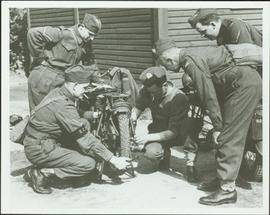 Working on a motorcycle at the No. 1 Canadian Provost Corps camp