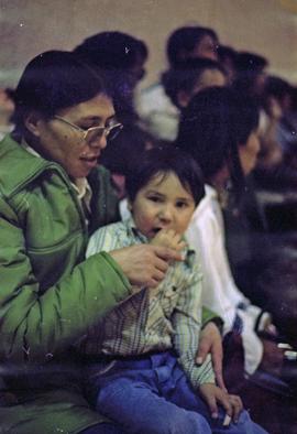 First Nations mother and child in auditorium crowd