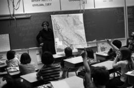 Iona Campagnolo standing beside a map of BC and talking to Haida Gwaii students
