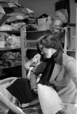 Iona Campagnolo and a young woman folding a quilt tapestry
