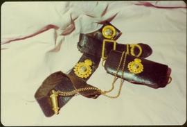 Closeup of Royal Irish Constabulary leather belt and case with attached gold badges and chain