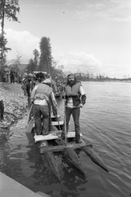 Iona Campagnolo and unidentified men stand on raft during Kitimat Delta King raft race