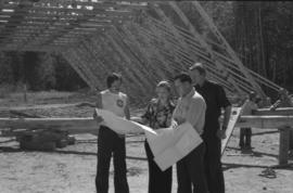 Iona Campagnolo and construction workers looking at plans at construction site
