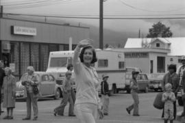 Iona Campagnolo waving to crowd in front of Smithers Bridal Store while walking in parade