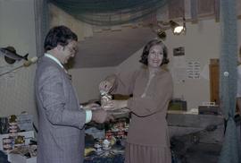 Iona Campagnolo opening can of salmon held by man at the opening of the Prince Rupert Fishing Exhibit