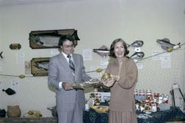 Iona Campagnolo with an opened tin of salmon and man at the opening of the Prince Rupert Fishing Exhibit