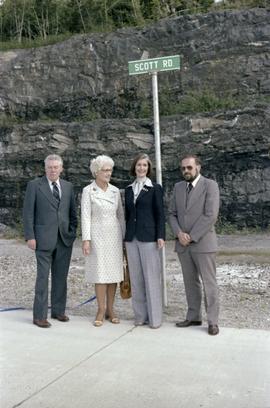 Iona Campagnolo, Joe Scott, and others posing by Scott Road sign at opening ceremony