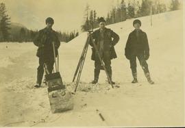 One surveyor and two survey crewman pose for a photo beside their equipment