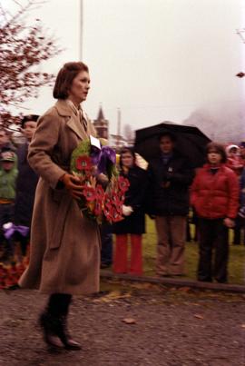 Iona Campagnolo walking with wreath in front of Prince Rupert courthouse at Remembrance Day ceremony