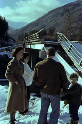 Iona Campagnolo with a family at damaged road and bridge from washout on Highway 16