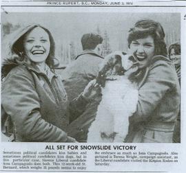 Iona Campagnolo being kissed by a twelve week St. Bernard puppy while visiting the Kispiox Rodeo with campaign assistant Teresa Wright