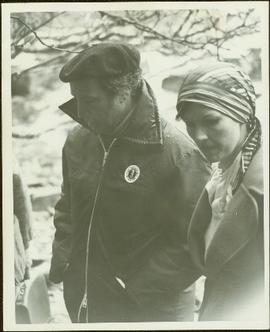 Close View of Prime Minister Pierre Trudeau wearing a beret and Mustang lifejacket, walking outsi...