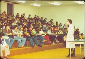 Minister Iona Campagnolo speaking to a lecture hall of youths at Granisle School, Granisle, BC