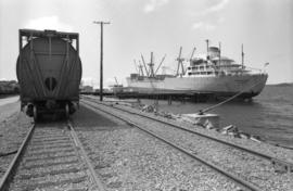 CN grain car on railroad tracks and docked ship “Aegean Sea” in Prince Rupert