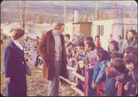 Minister Iona Campagnolo and Hugh Faulkner greet a group of children leaning over wooden fences d...