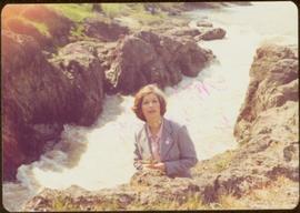 Minister Iona Campagnolo holds bouquet of wildflowers with Moricetown Canyon in background, summer 1977