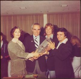 Iona Campagnolo handing celebratory vase to two unidentified men and Marcel Dionne after the Inte...