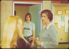 Iona Campagnolo speaking with an unidentified girl in classroom, while another unidentified girl watches