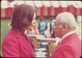 Commonwealth Games, Edmonton 1978 - Iona Campagnolo speaks to an unidentified man, both in red sp...