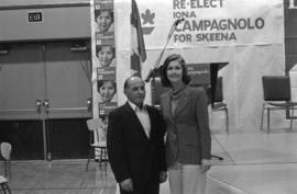 Iona Campagnolo posing with man in front of podium for her Liberal re-election campaign