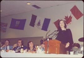 Canada Winter Games, Brandon, MB - Iona Campagnolo speaks at podium set on banquet table, unidentified men and women on left