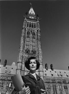 Iona Campagnolo holding folders and standing in front of Peace Tower in Liberal publicity portrait