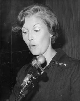 Iona Campagnolo speaking at microphone and wearing pin for 1980 Olympics in Liberal publicity image