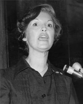Iona Campagnolo speaking at microphone in Liberal publicity image
