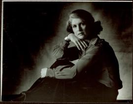 CBC Publicity Photos - Iona Campagnolo facing left, with one hand on her knee and one hand folded beneath her chin